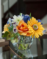 Yellow and blue gerbera daisy, rose and cornflower silk accent in tapered square glass vase
