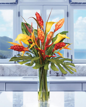 Perfect Paradise Faux Flower Tropical Arrangement in a 12” tall glass cylinder vase of clear acrylic water. Available at Petals.