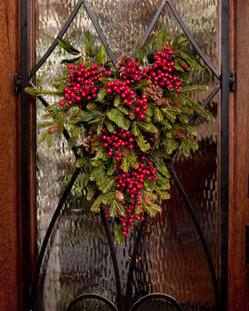 Pine and berry silk swag 16" wide teardrop of pine winter greens and cones with shiny red berries on a decorative metal base